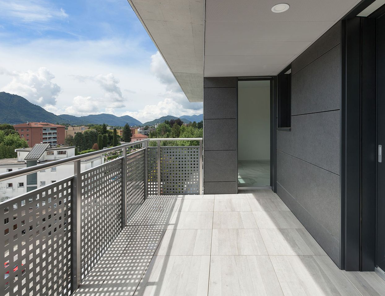Balkon mit hellen Fliesen und Metallverkleidung