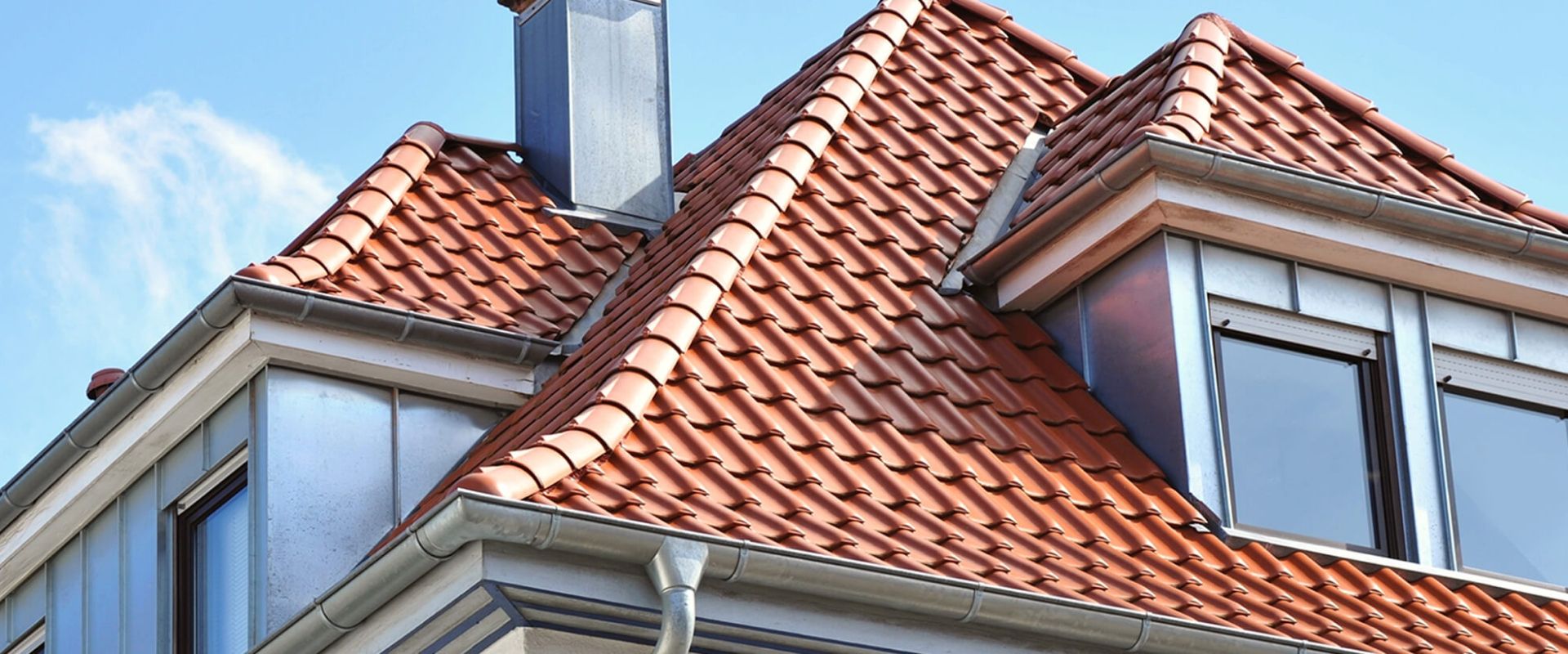 Rotes Dach mit Gauben und Kamin